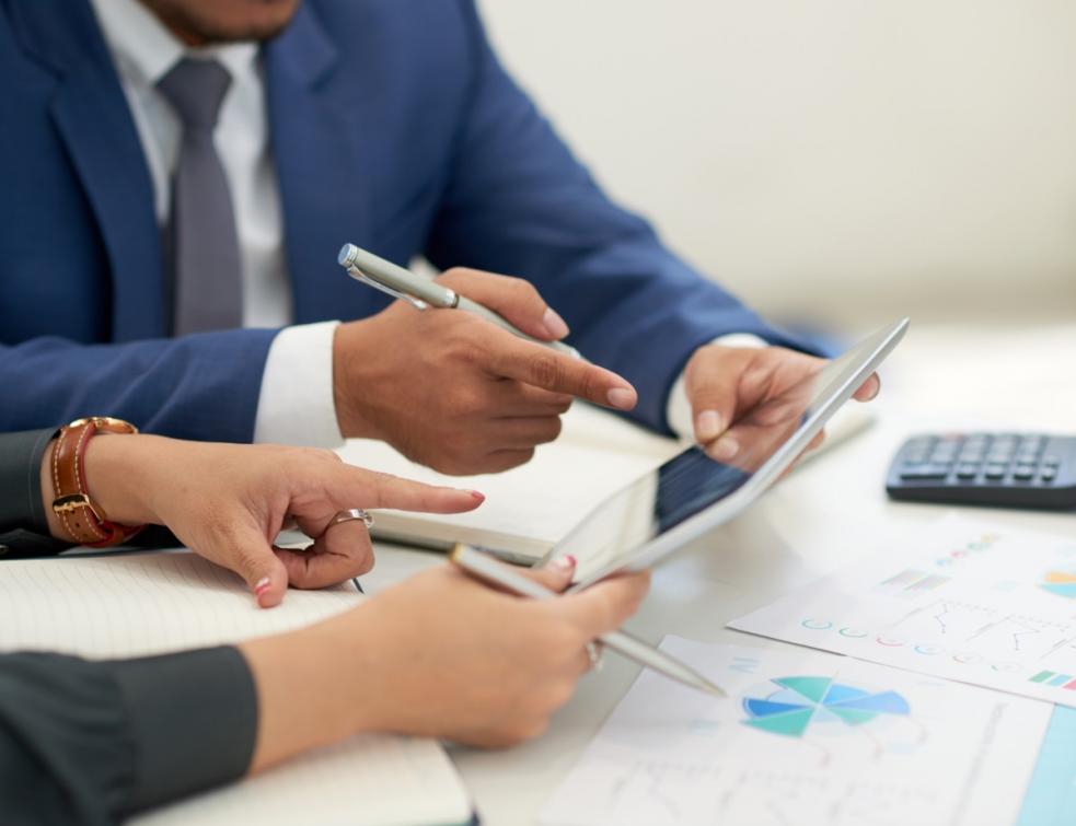 Deux personnes se penchant sur des rapports en entreprise.