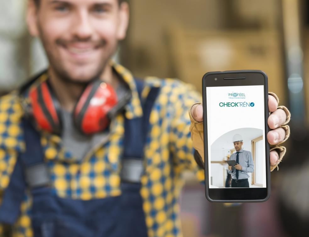 Artisan tenant un téléphone à la main, ouvert sur l'application 